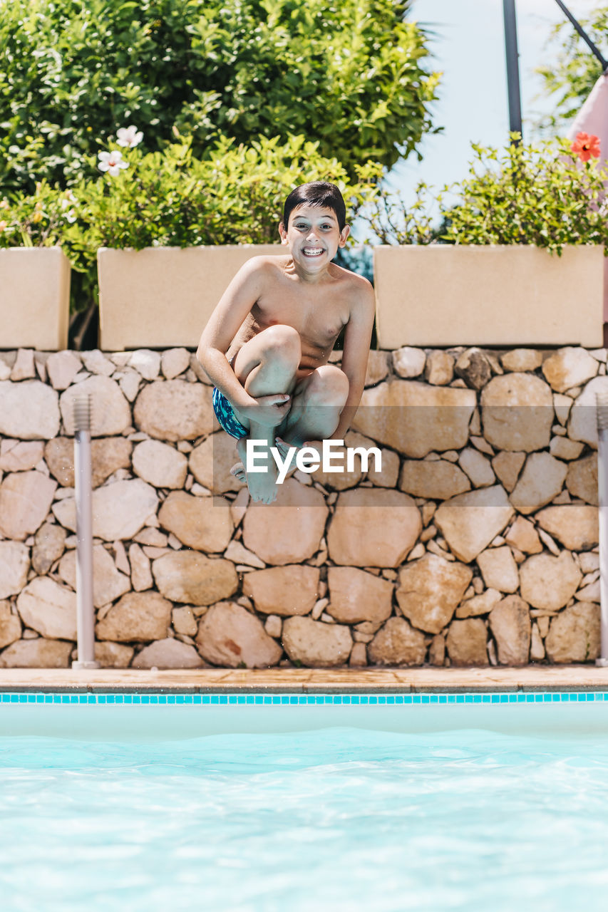 Portrait of boy jumping in swimming pool