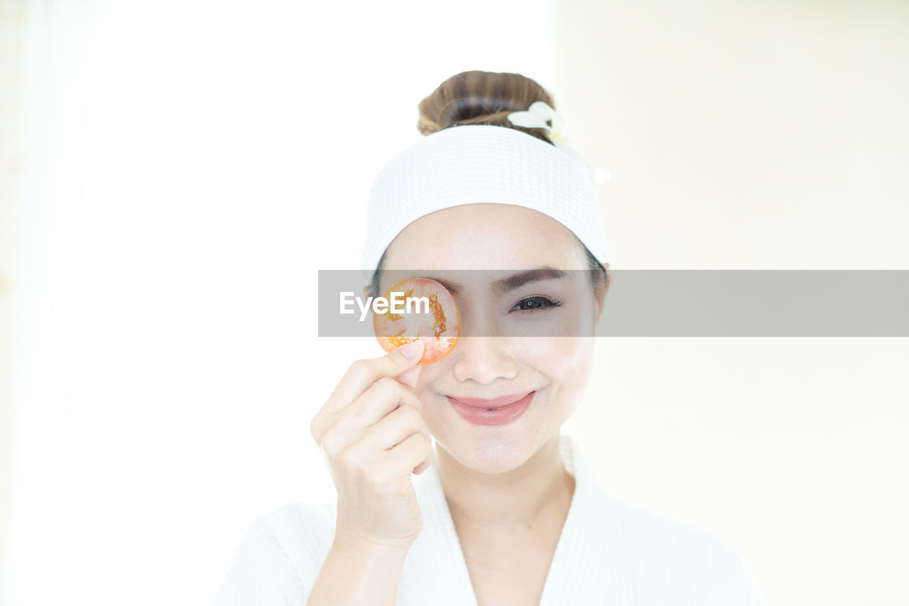 Beauty and spa condo, woman holding cucumber. young woman with facial mask holding cucumber slices