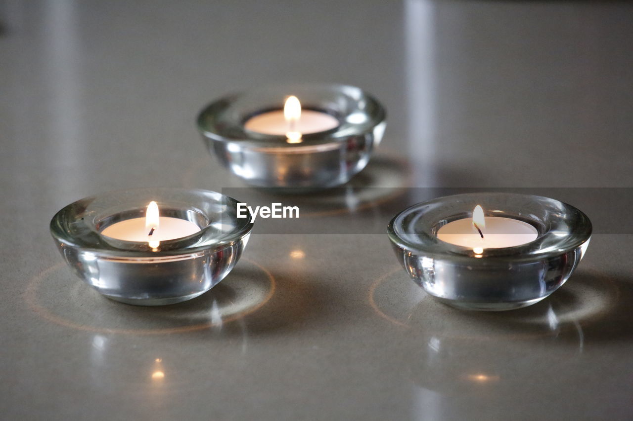 Close-up of illuminated tea light candles in building