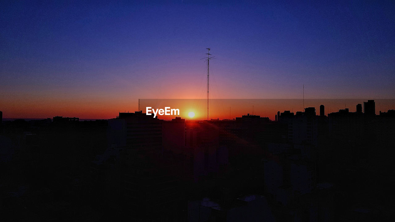 Silhouette buildings against sky during sunset