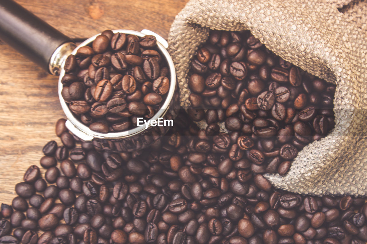 Close-up of roasted coffee beans with serving scoop and sack