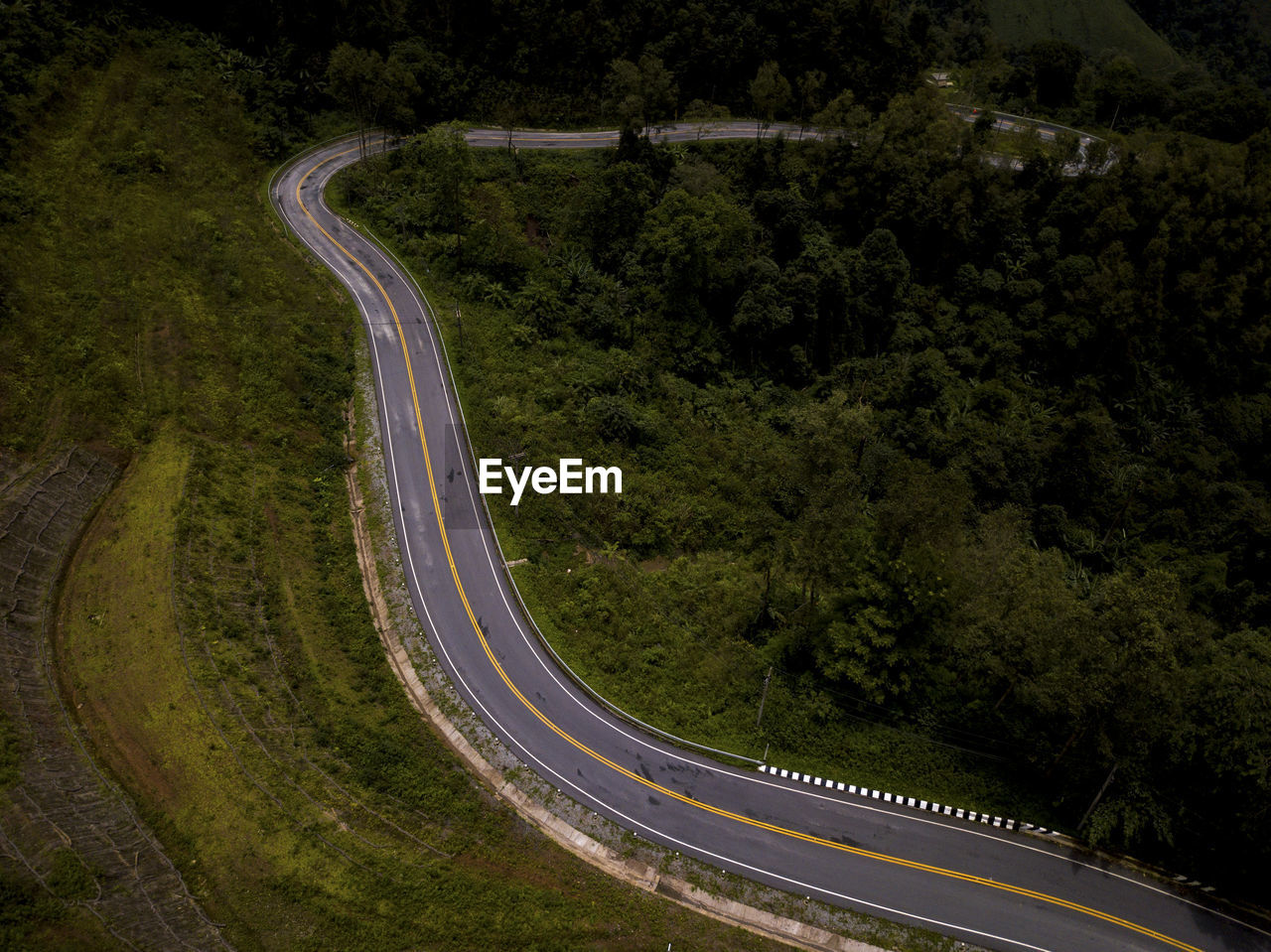 Aerial view of countryside road on the lush greenery tropical rain forest mountain landscape