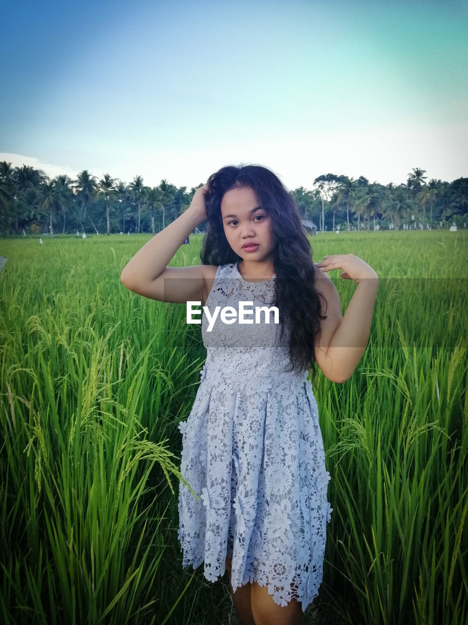 BEAUTIFUL YOUNG WOMAN STANDING IN FIELD