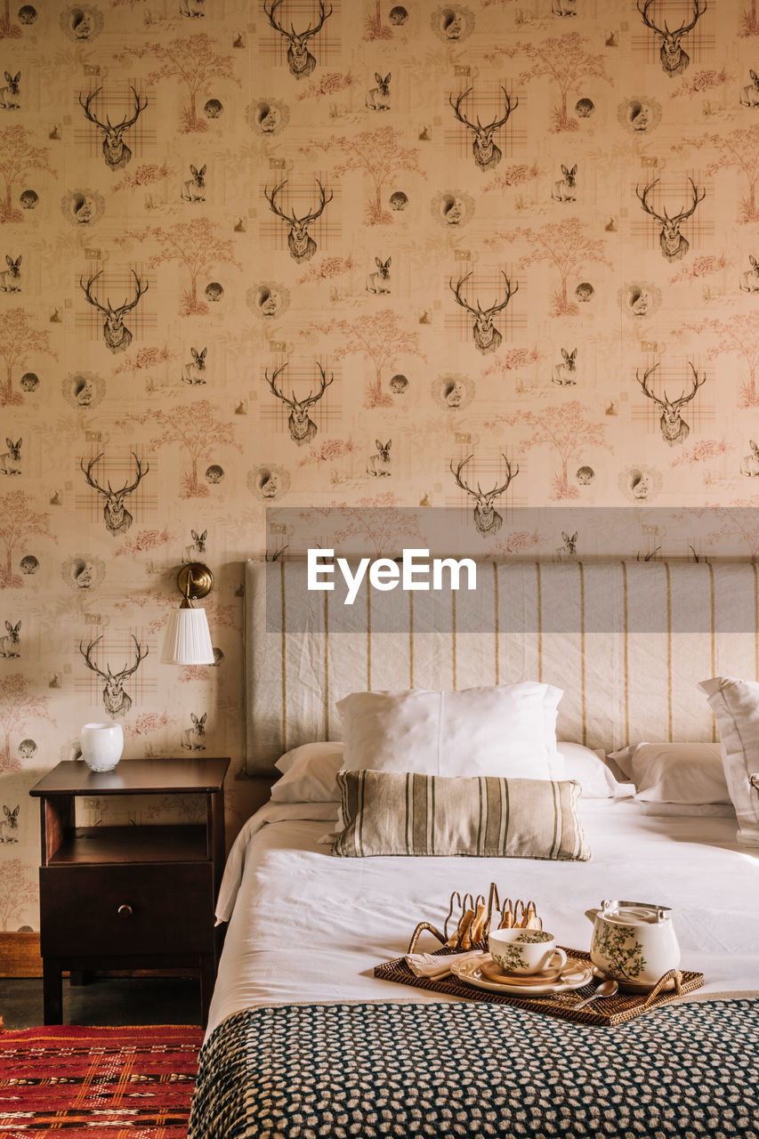 Interior of stylish bedroom with comfortable bed covered with coverlet