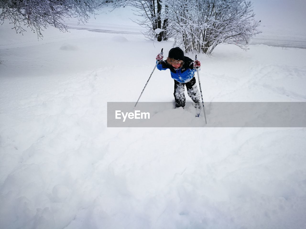 High angle view of boy walking on snow covered land