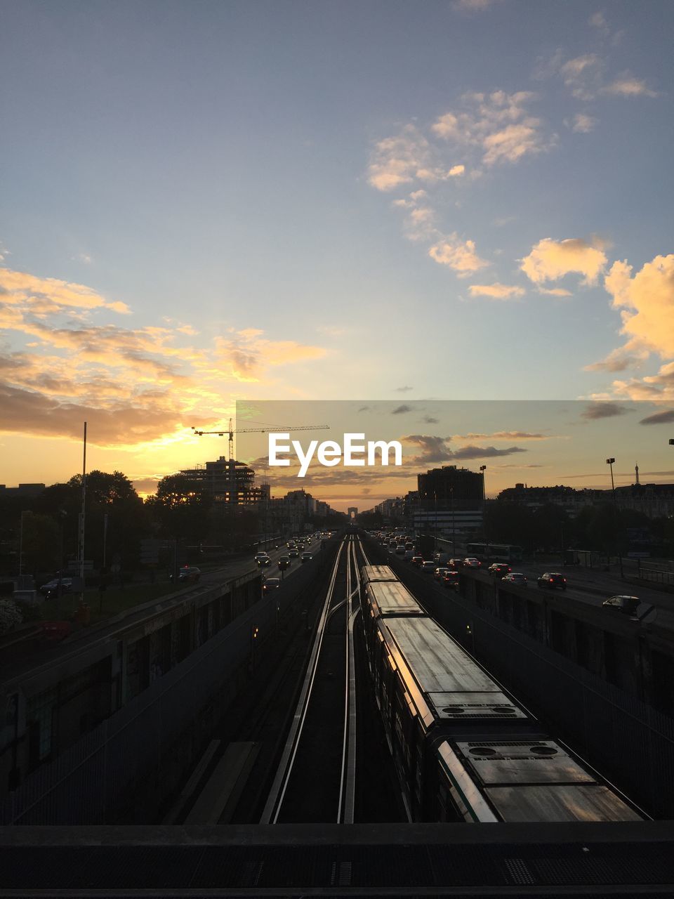 TRAIN PASSING THROUGH CITY DURING SUNSET