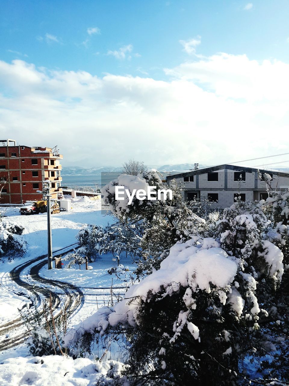 SNOW COVERED BUILDINGS AGAINST SKY IN CITY