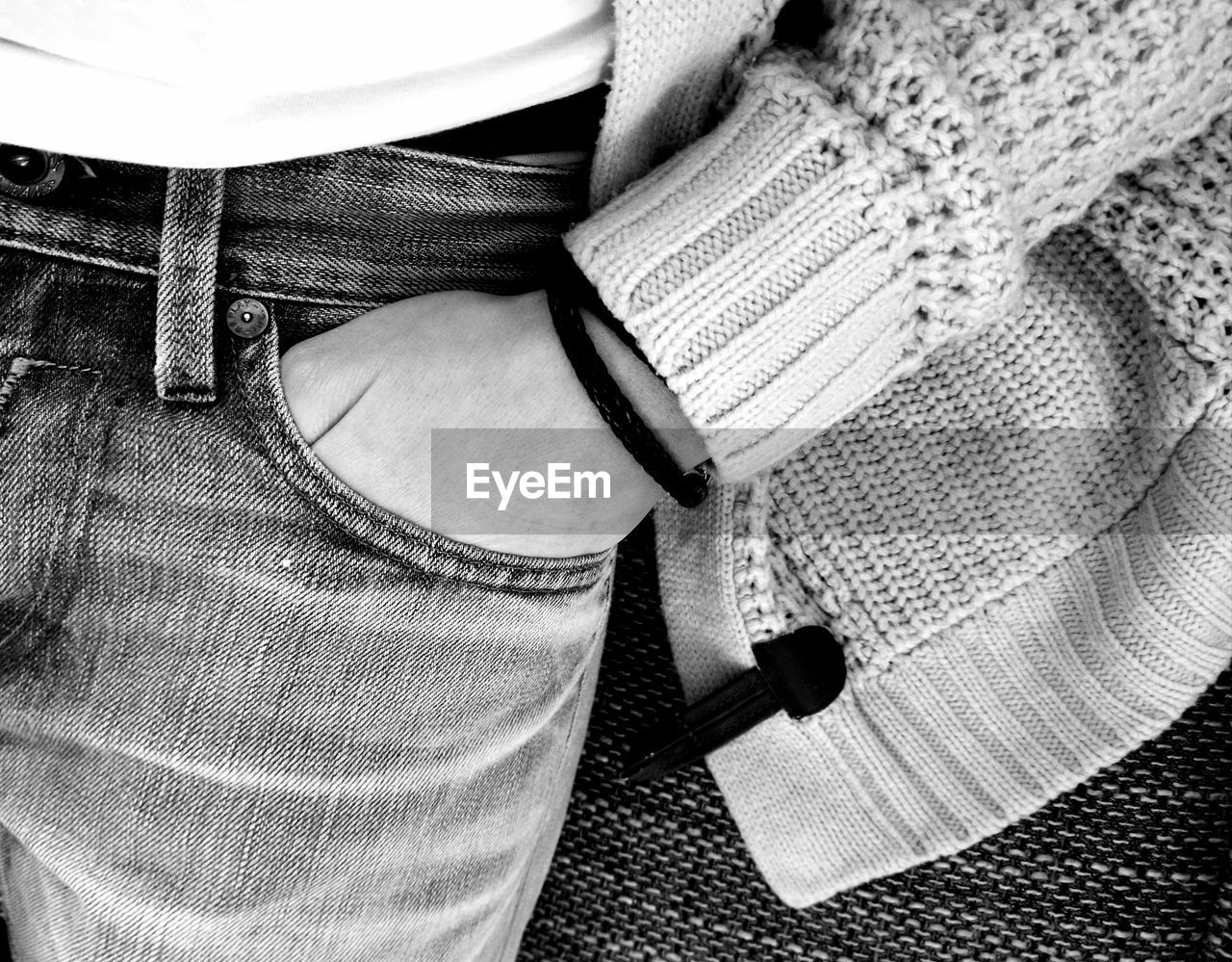 Midsection of person with hand in pocket