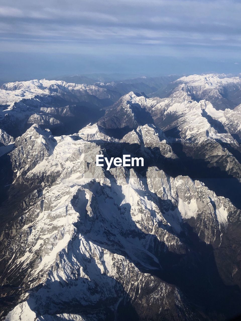 Aerial view of snowcapped mountains against sky