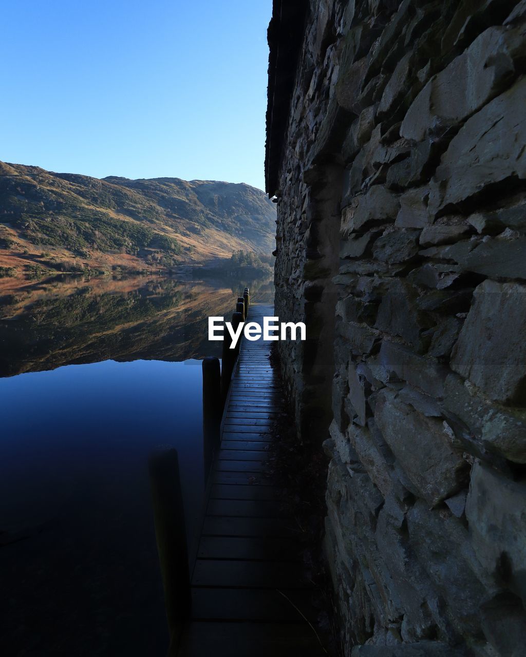 Scenic view of sea and mountains against clear sky