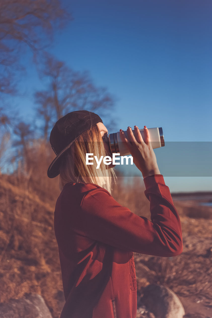 REAR VIEW OF WOMAN PHOTOGRAPHING CAMERA