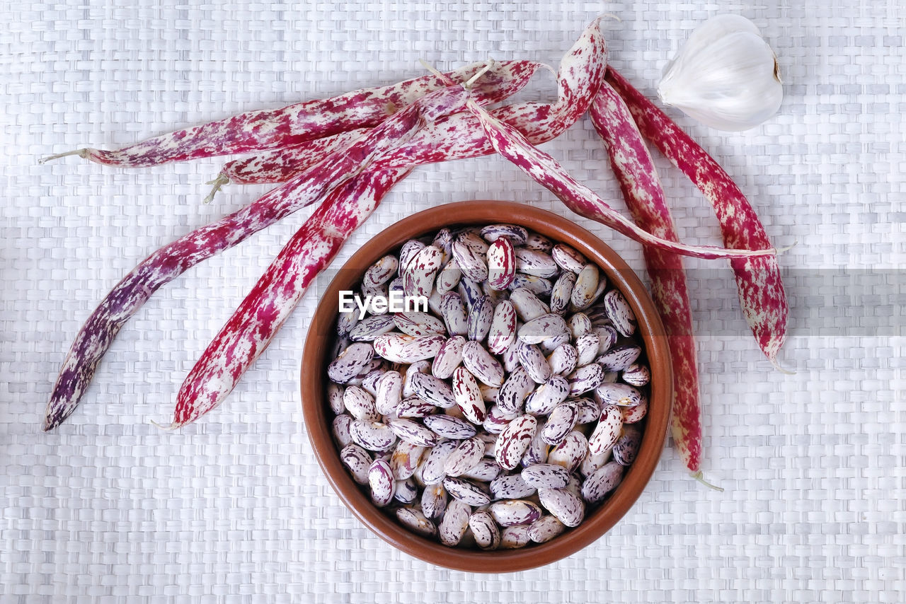 Close-up of beans in bowl with garlic on table