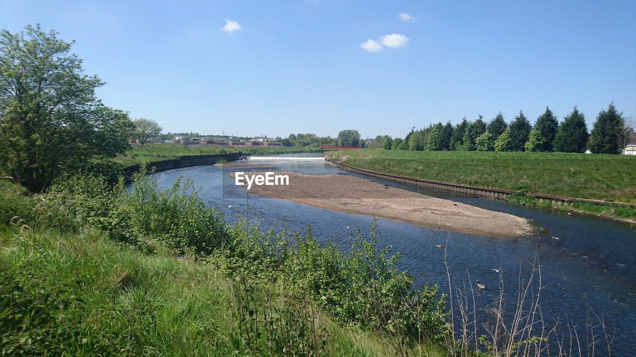 SCENIC VIEW OF RIVER AND FIELD AGAINST SKY