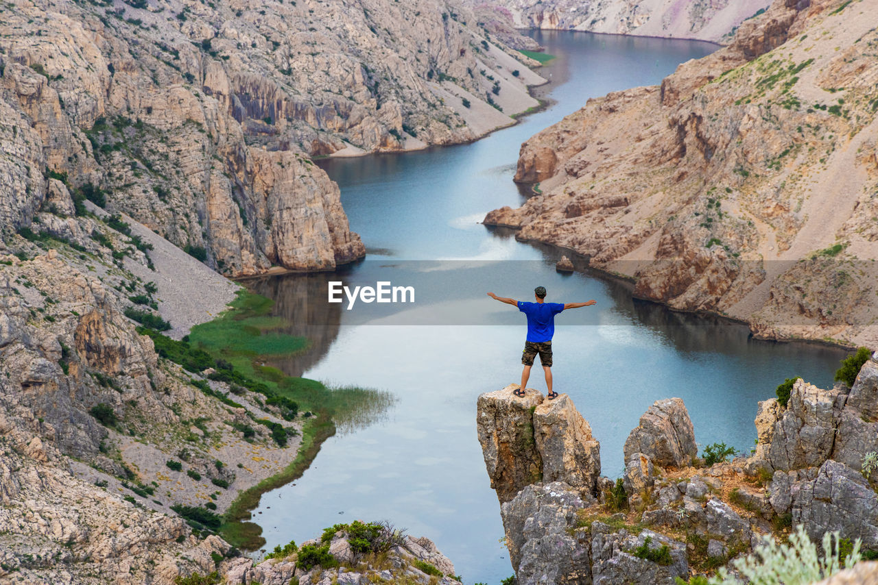 Man is standing on the cliff above the canyon of the zrmanja river, croatia