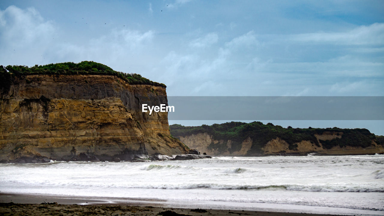 sea, water, land, ocean, beach, coast, shore, rock, body of water, wave, sky, cliff, nature, scenics - nature, beauty in nature, environment, coastline, cloud, bay, rock formation, travel destinations, motion, surfing, travel, sand, sports, cove, landscape, wind wave, water sports, terrain, outdoors, seascape, tourism, holiday, trip, coastal feature, non-urban scene, tranquility, water's edge, vacation, tranquil scene, horizon, animal wildlife, day