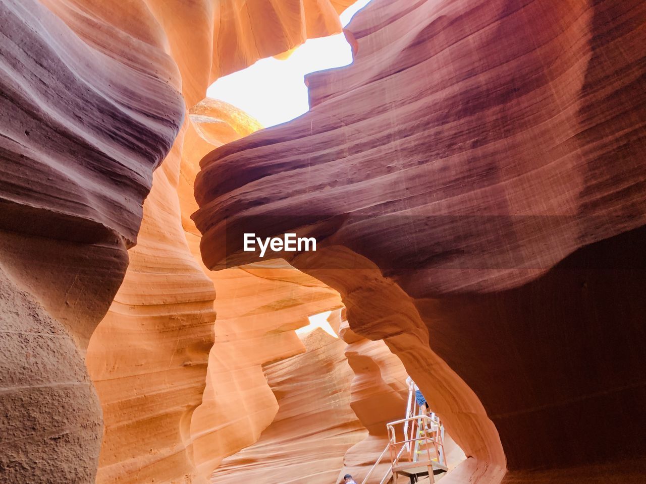 Low section of man on ladder by rock formations