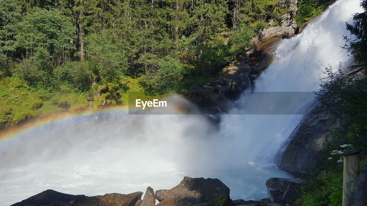 WATERFALL IN FOREST AGAINST SKY