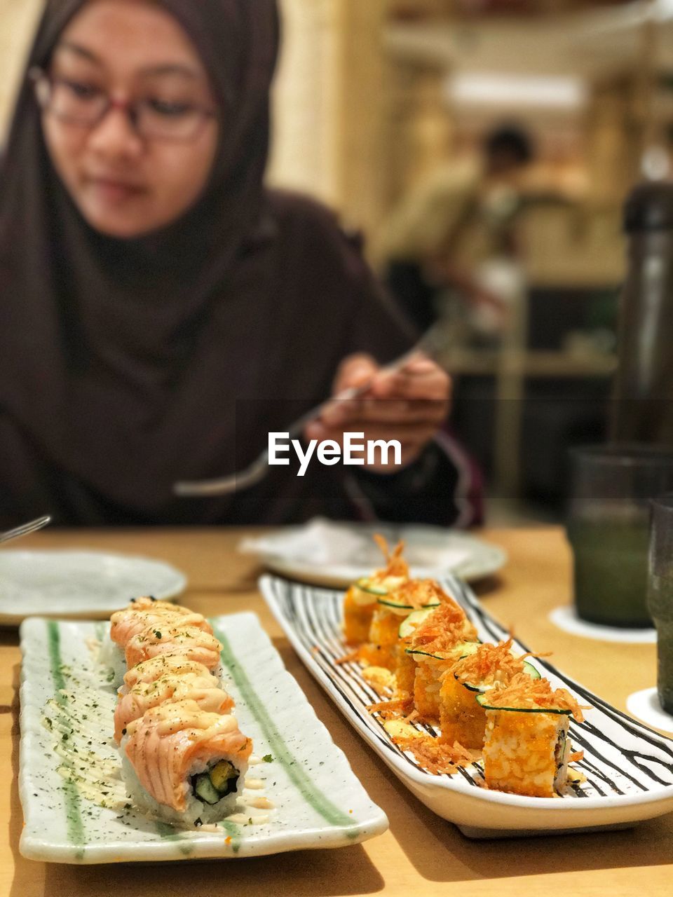 Close-up of woman having sushi in restaurant