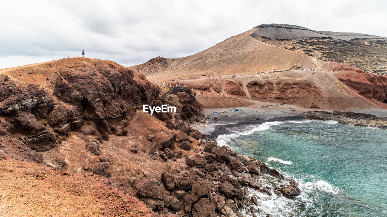 Scenic view of rock formation in sea against sky