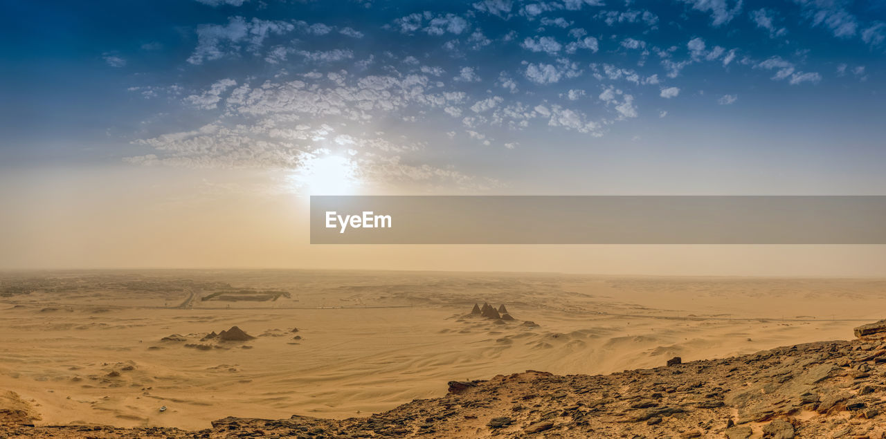 Scenic view of desert against sky during sunset