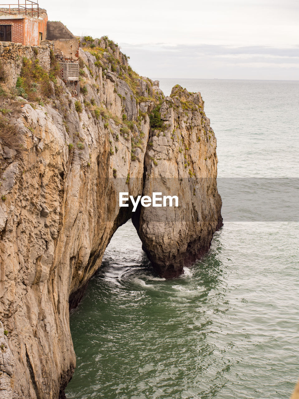 Rock formation in sea against sky