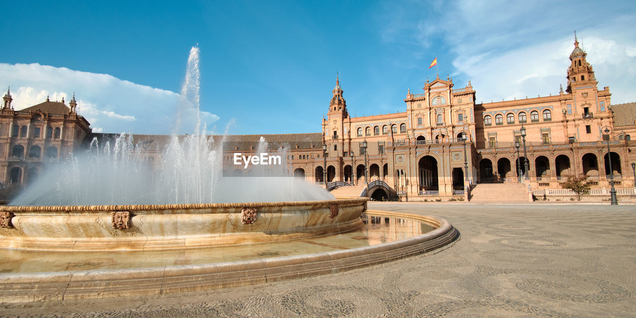 Fountain against buildings in city