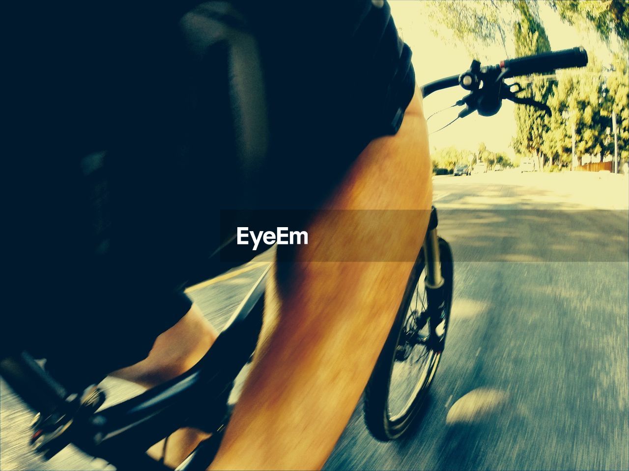 Mid section of man bicycling on road