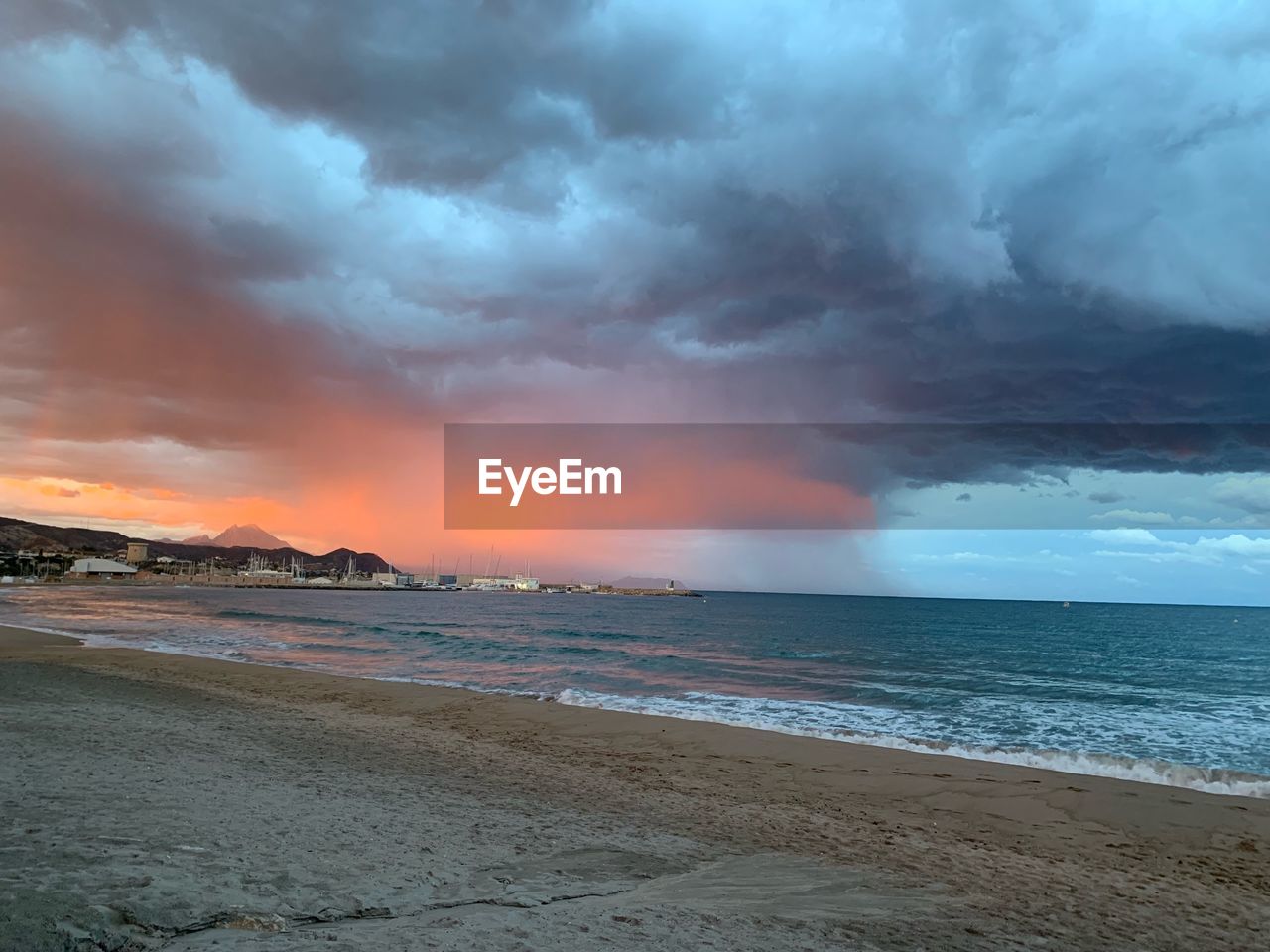 SCENIC VIEW OF BEACH AGAINST SKY AT SUNSET