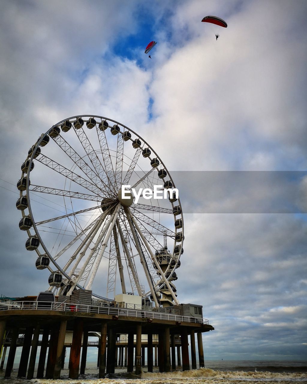 LOW ANGLE VIEW OF FERRIS WHEEL IN SEA