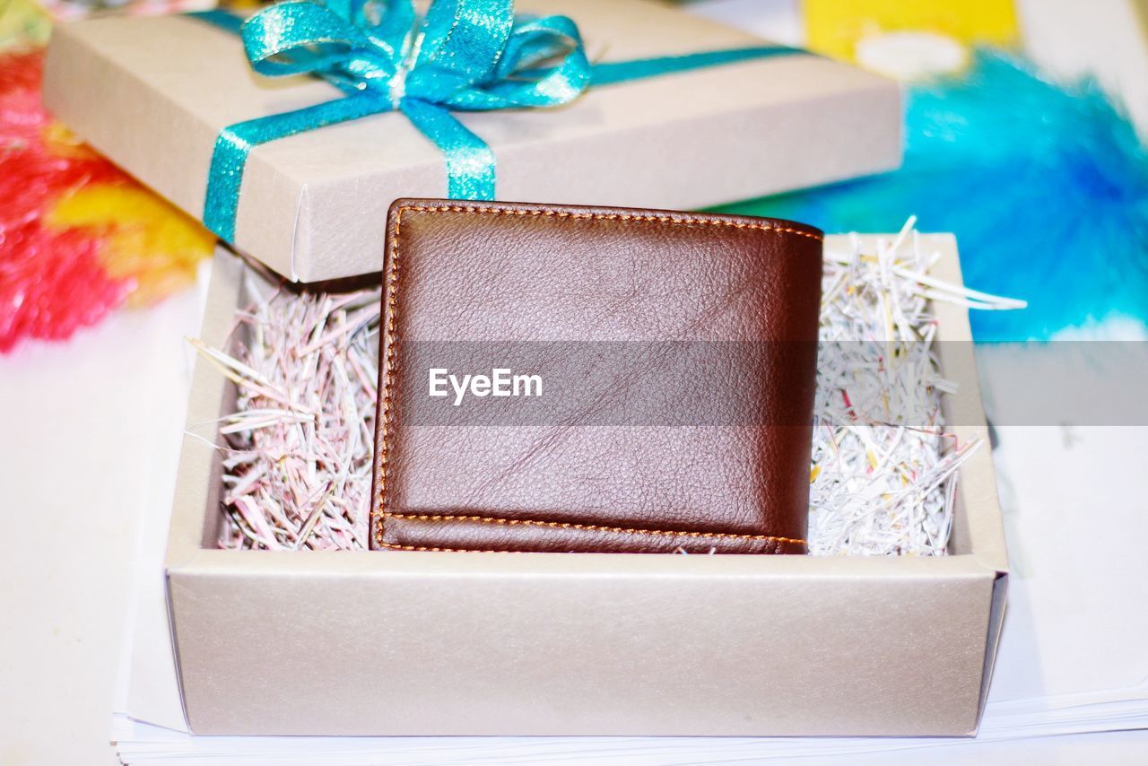 High angle view of wallet in gift box on table