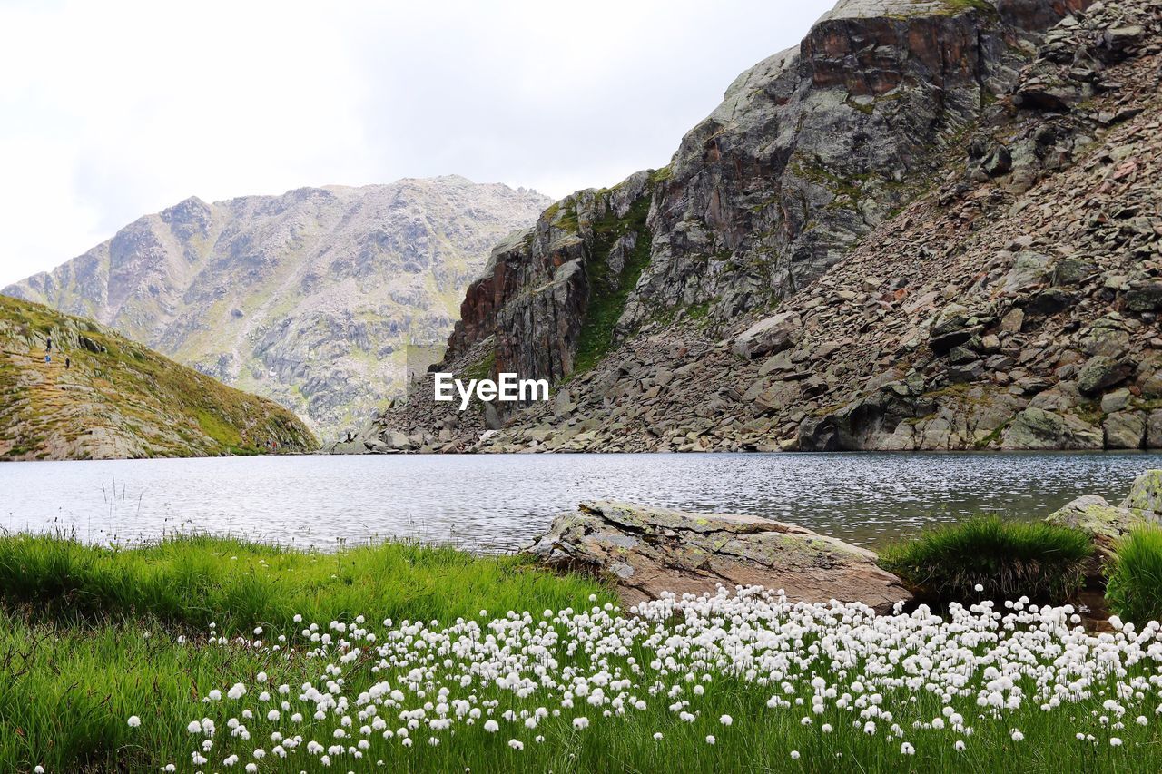 Scenic view of lake by mountain against sky