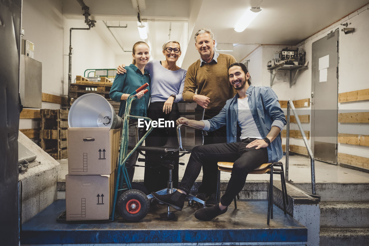 Portrait of smiling business people with equipment in new office