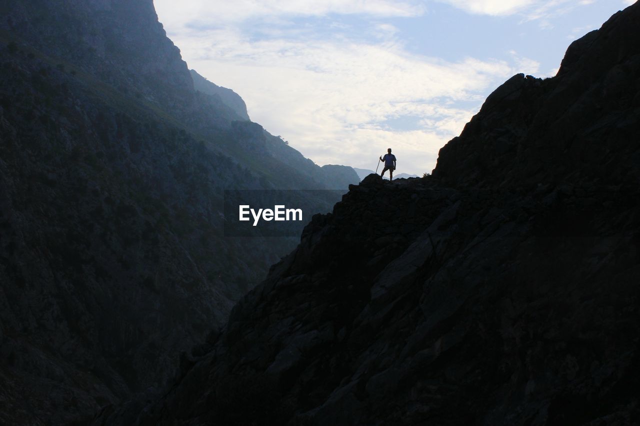 Low angle view of man standing on mountain