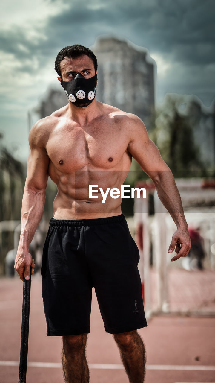 Shirtless man standing on running track