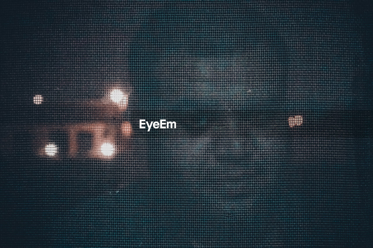 Portrait of man seen through metal grate at night