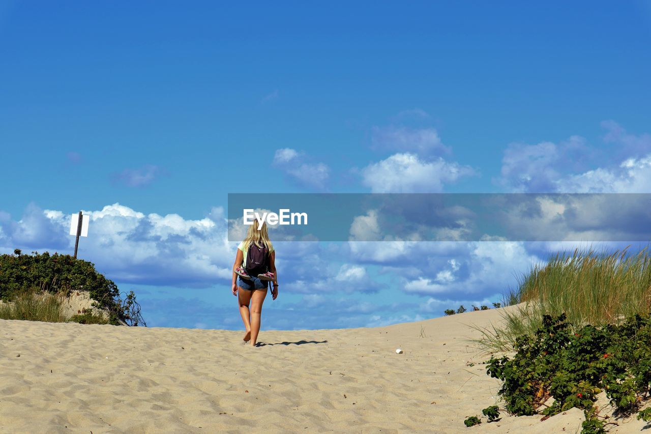 FULL LENGTH REAR VIEW OF WOMAN STANDING ON BEACH