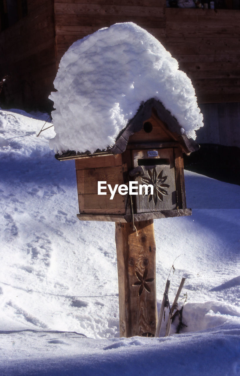 Public mailbox on snowcapped field at night