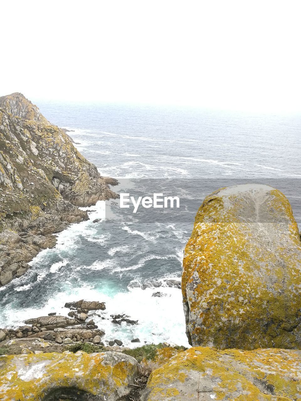 ROCKS IN SEA AGAINST CLEAR SKY