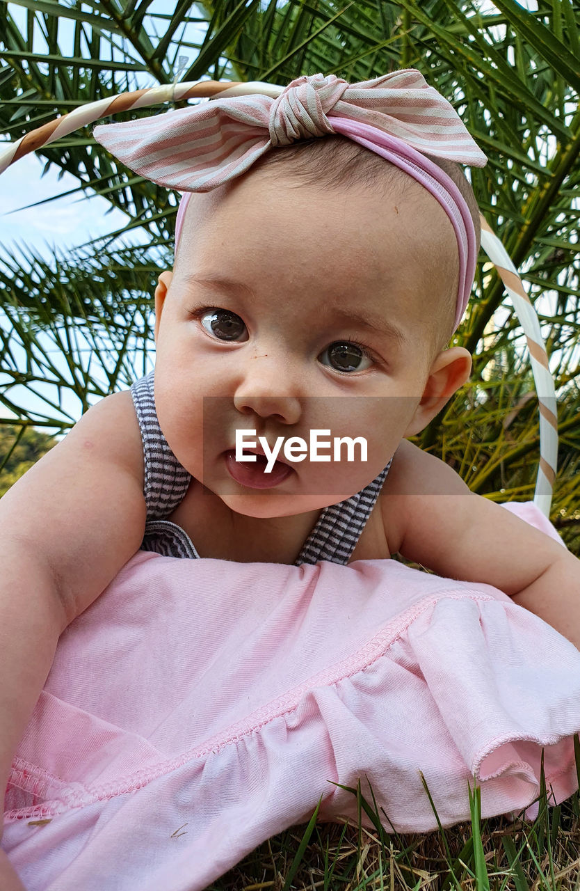 Portrait of cute baby girl on grass