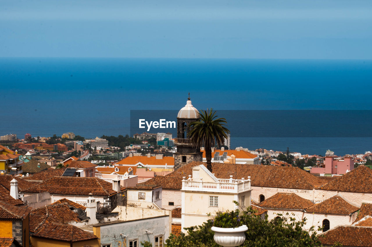 High angle view of buildings by sea against sky