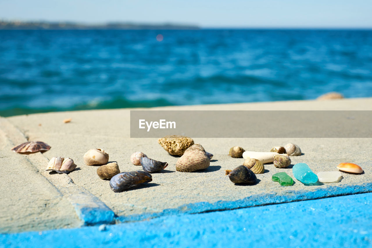 Close-up of pebbles on beach against sky