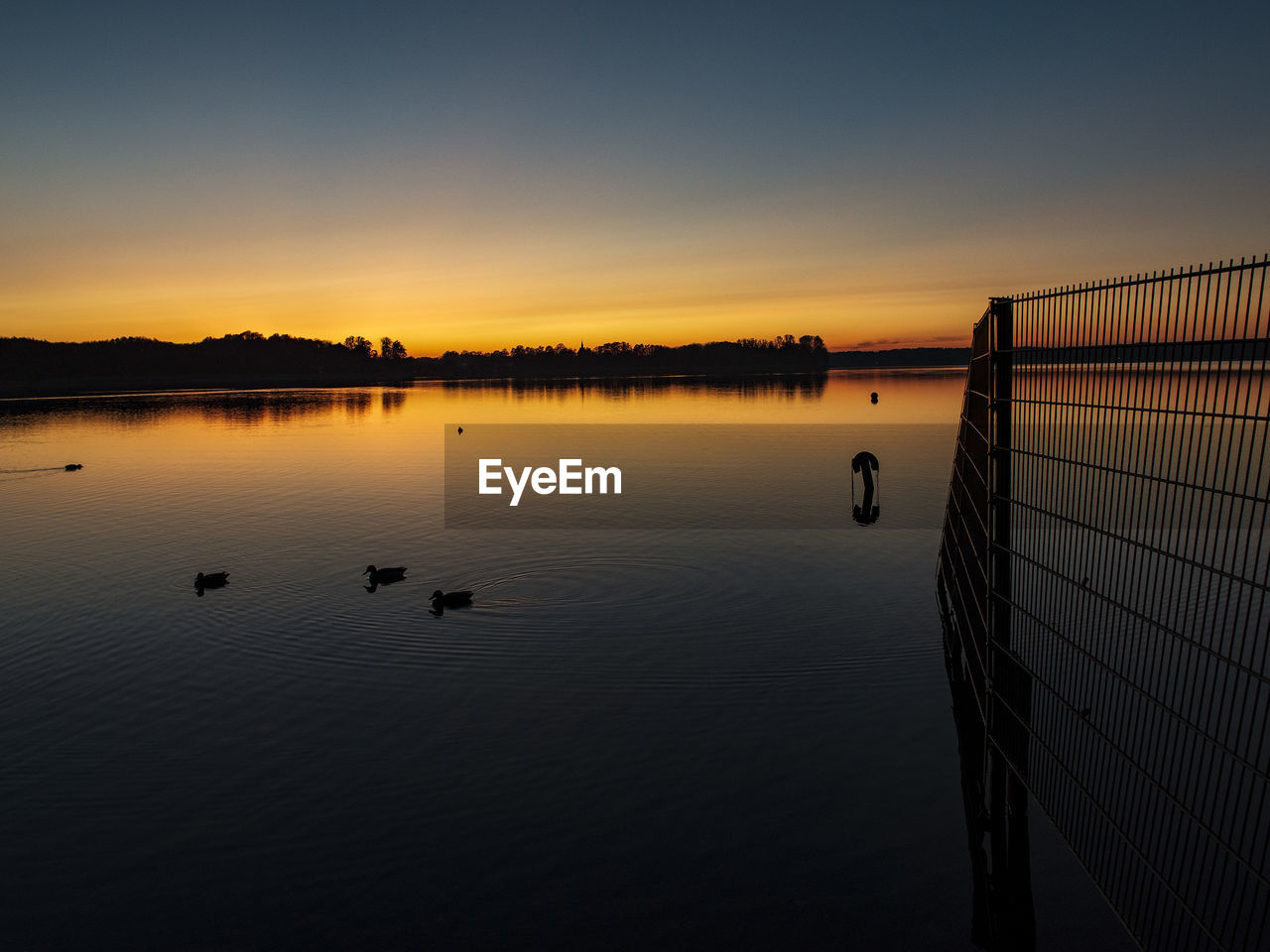 Scenic view of lake against sky during sunset