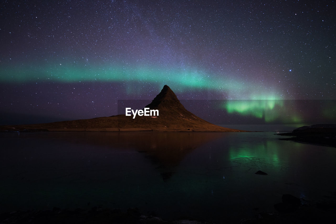 Scenic view of lake against sky at night