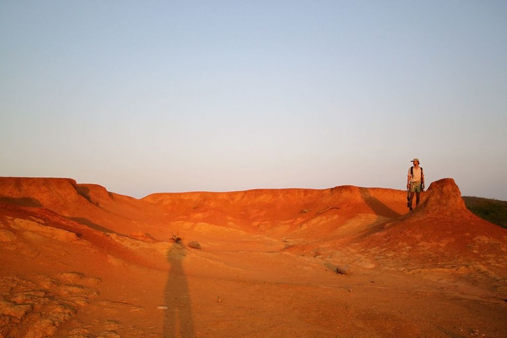 Man hiking on mountain against clear sky