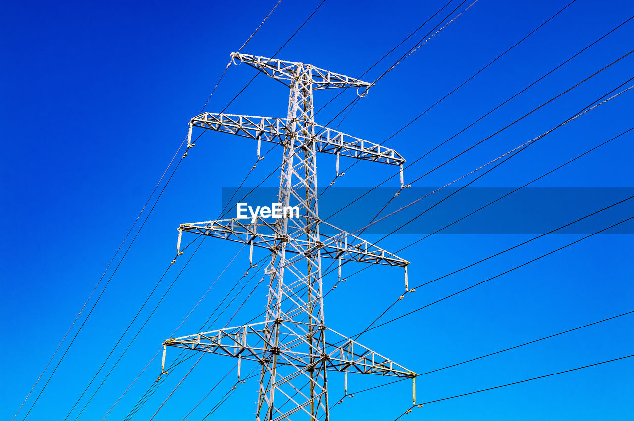 High-voltage power line and blue color metal prop with many electrical wires close up