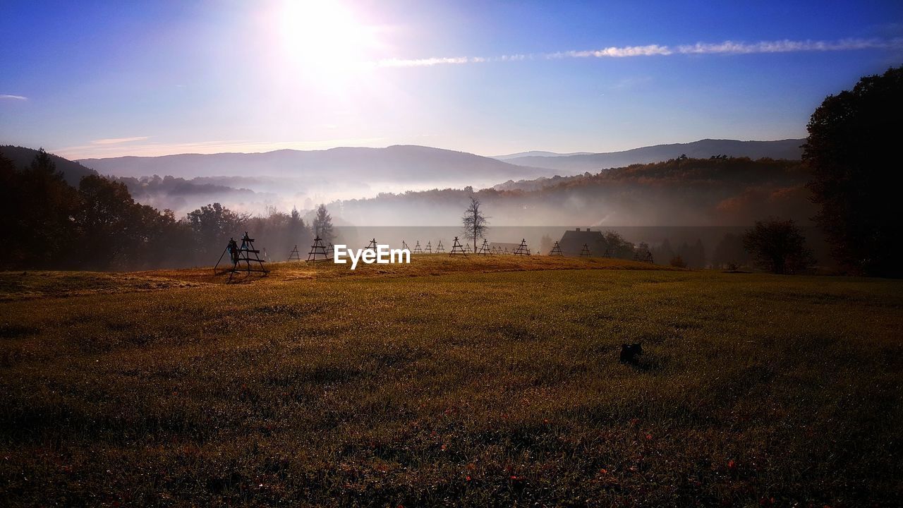 Scenic view of field against sky during foggy weather