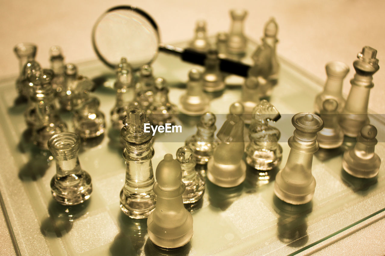 High angle view of glass chess pieces on board