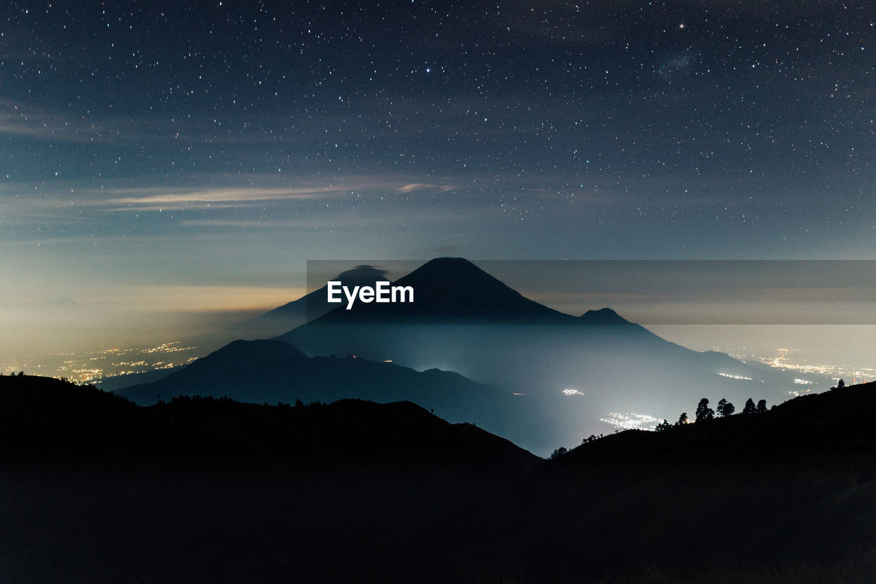 Scenic view of silhouette mountains against sky at night