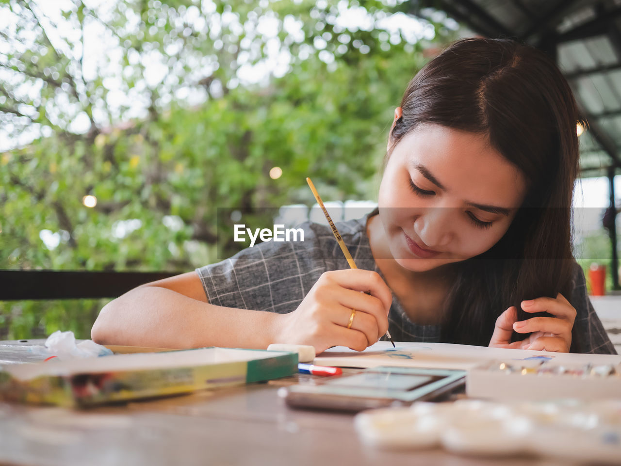 Girl painting on paper over table