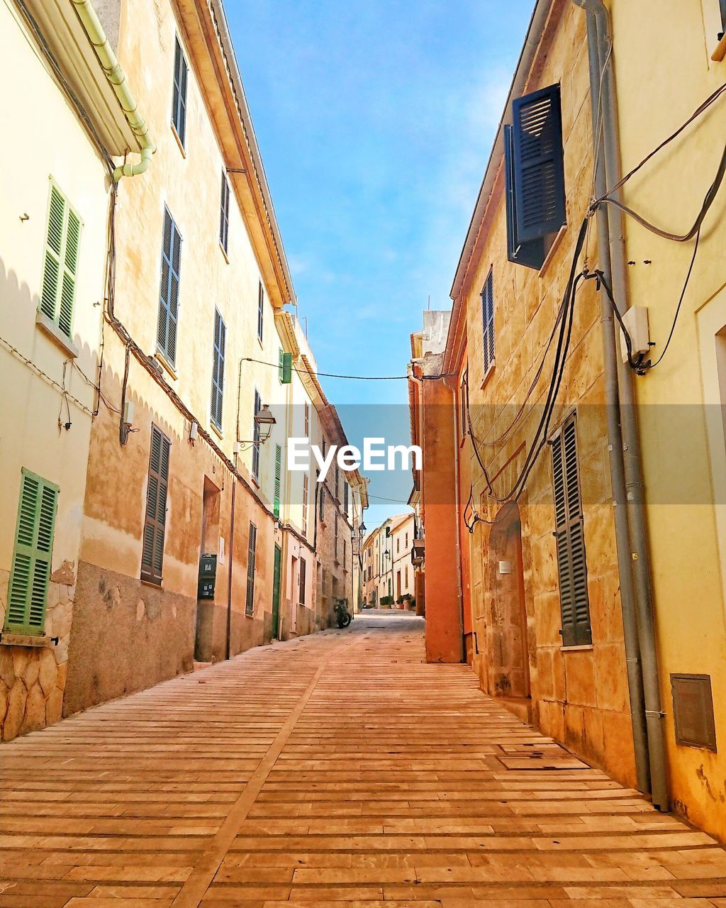 Narrow alley amidst buildings against sky